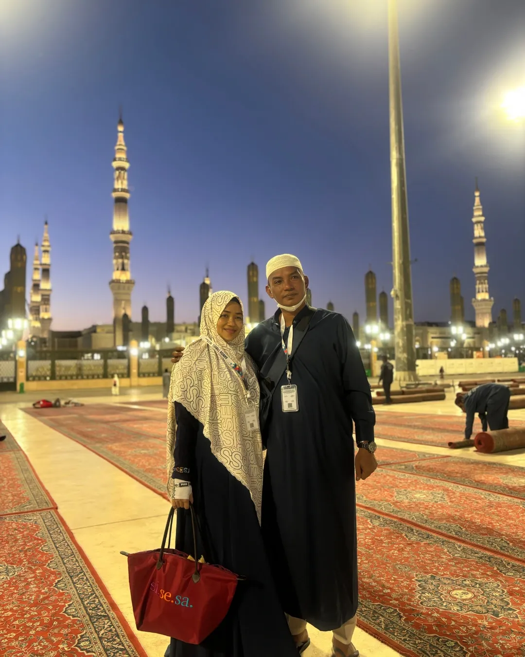 Pasangan jamaah haji di sekitar menara Masjid Nabawi, Madinah